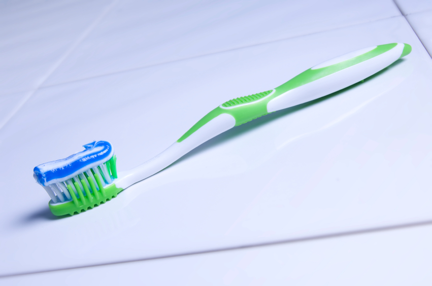 Zahnbürste und Zahnpasta auf Fliese